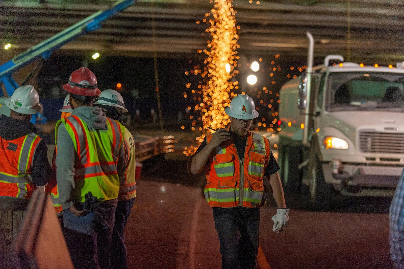 International construction workforce on-site at night