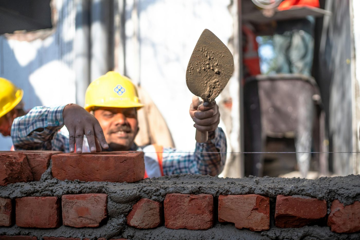 Mason laying bricks with trowel and mortar