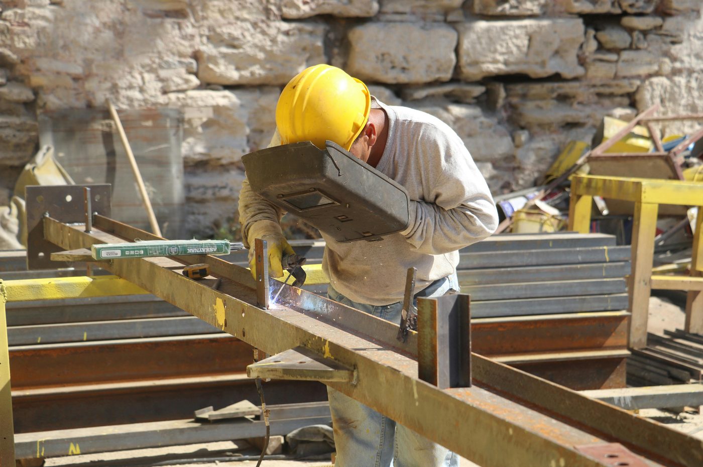 Welder fabricating steel structure on-site