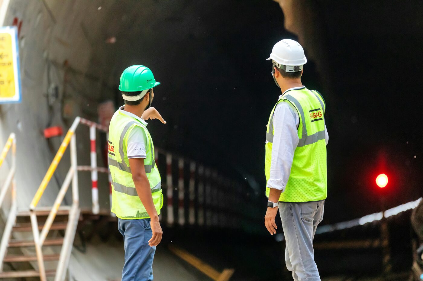 Site supervisors in high-visibility vests inspecting tunnel construction